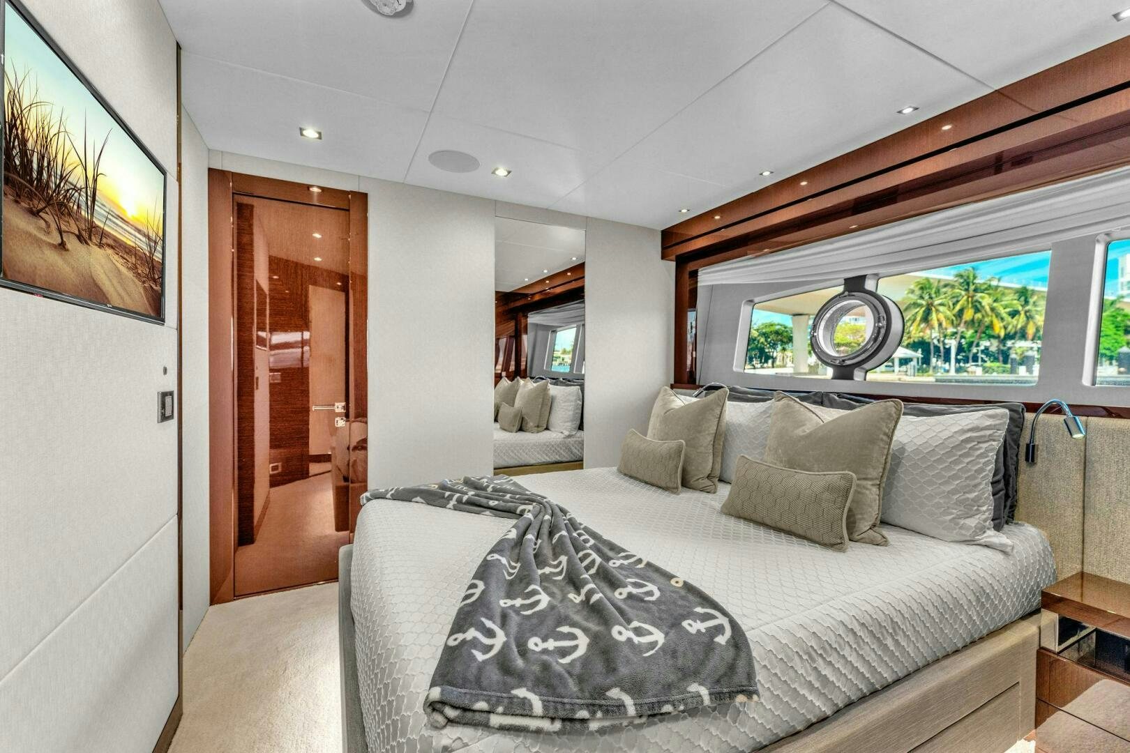 a bedroom with a bed and a large window aboard KARILLIAN & COMPANY Yacht for Sale