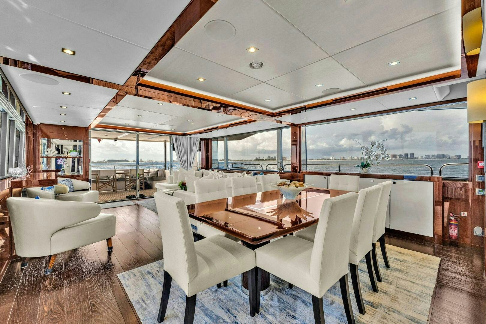 a room with a table chairs and a view of the city aboard KARILLIAN & COMPANY Yacht for Sale