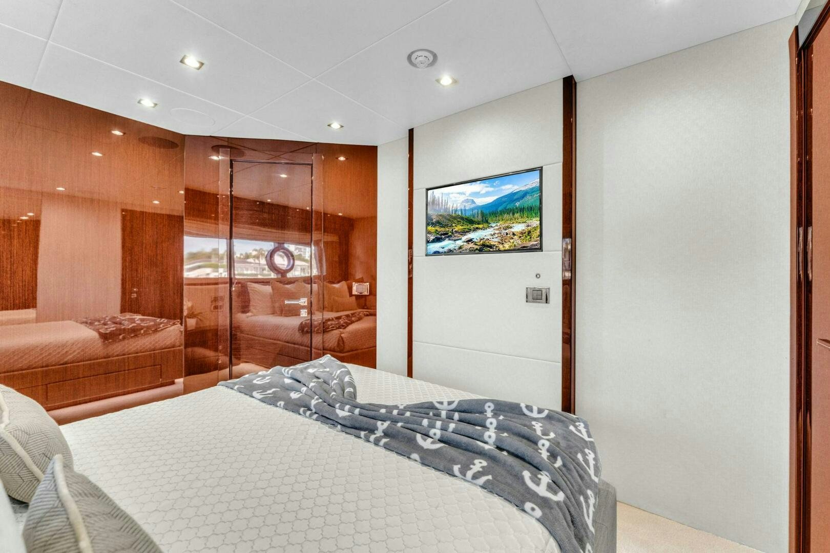 a bedroom with a bed and a glass door aboard KARILLIAN & COMPANY Yacht for Sale