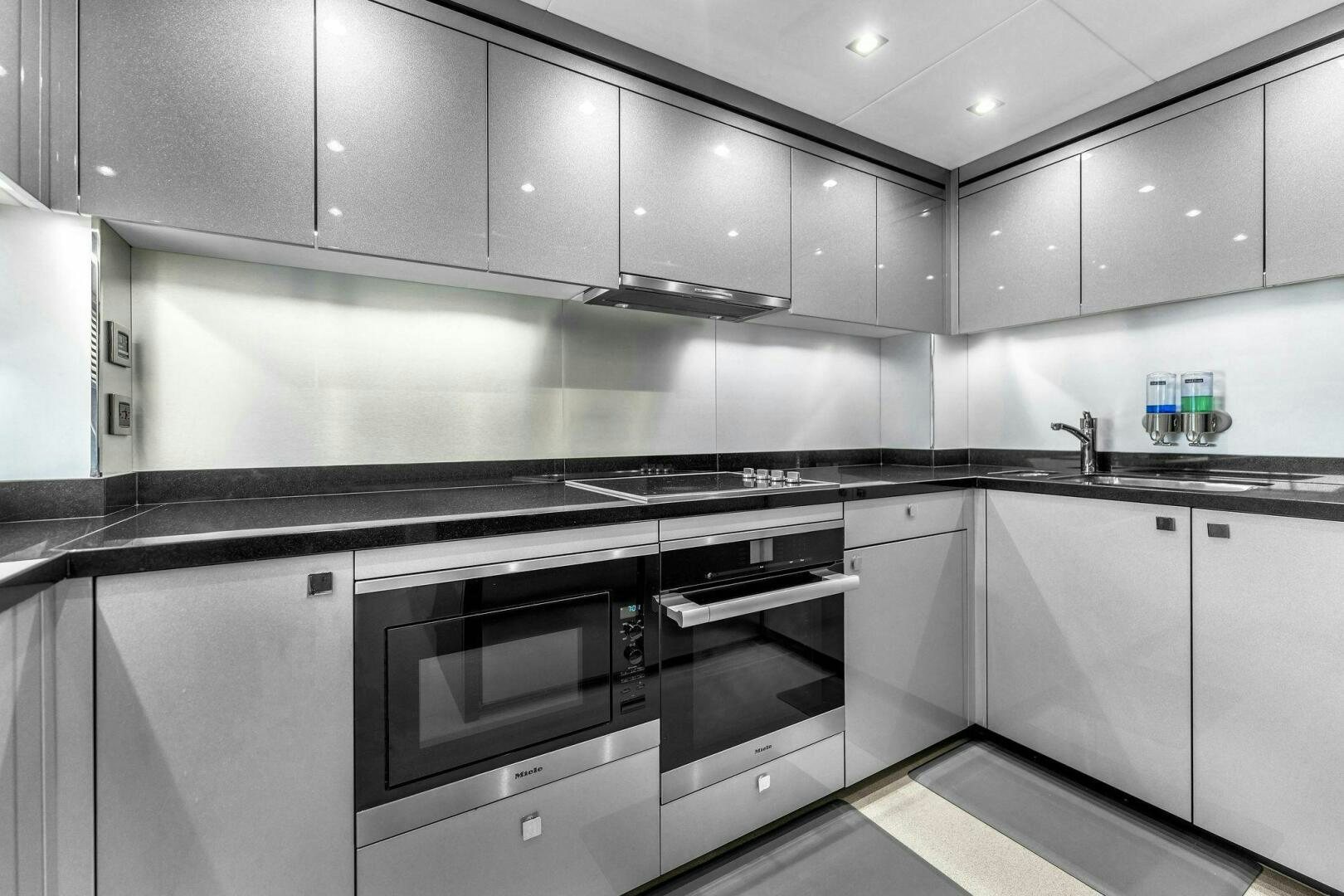 a kitchen with white cabinets aboard KARILLIAN & COMPANY Yacht for Sale