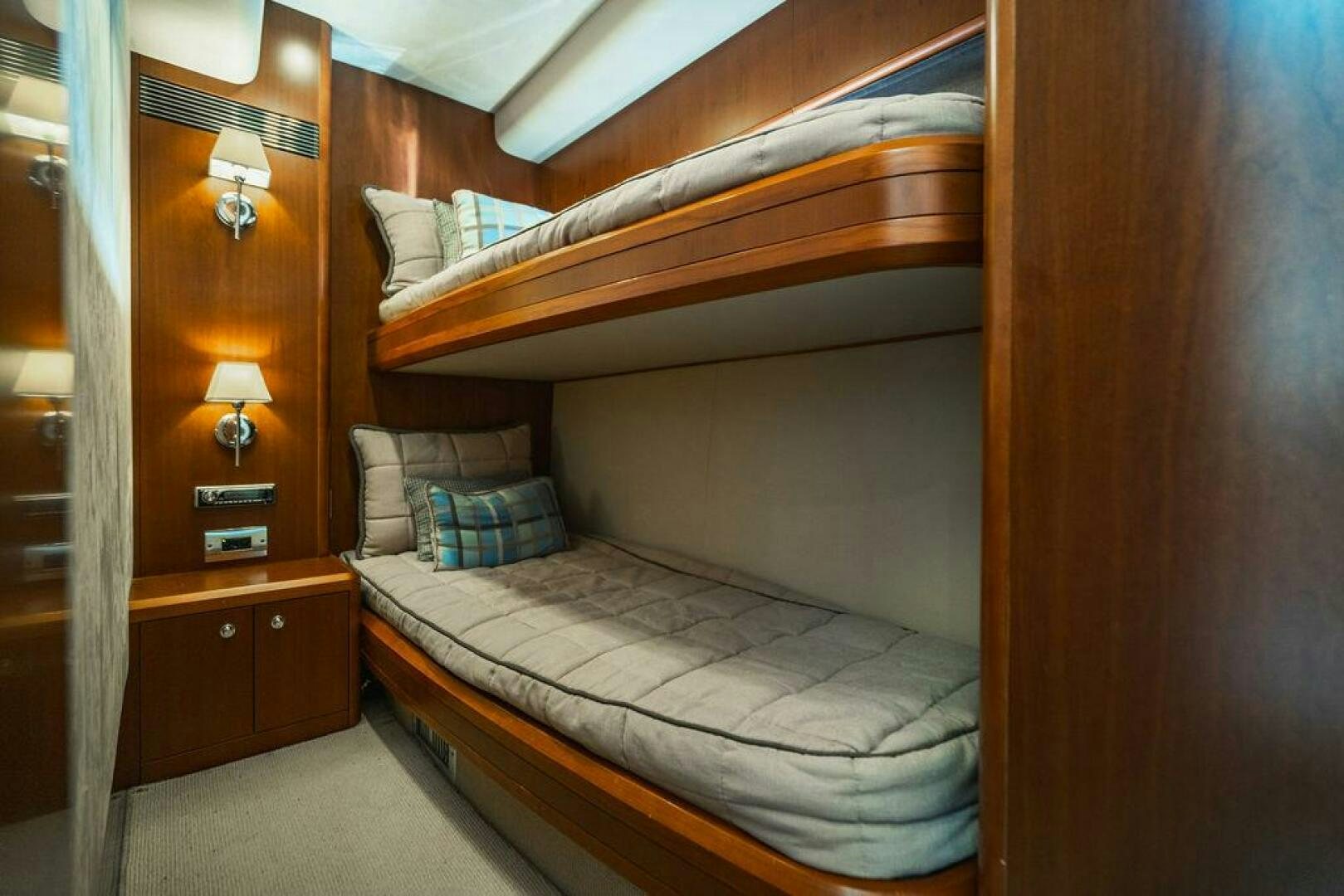 a bed with a wooden headboard aboard EMPIRE SUN Yacht for Sale
