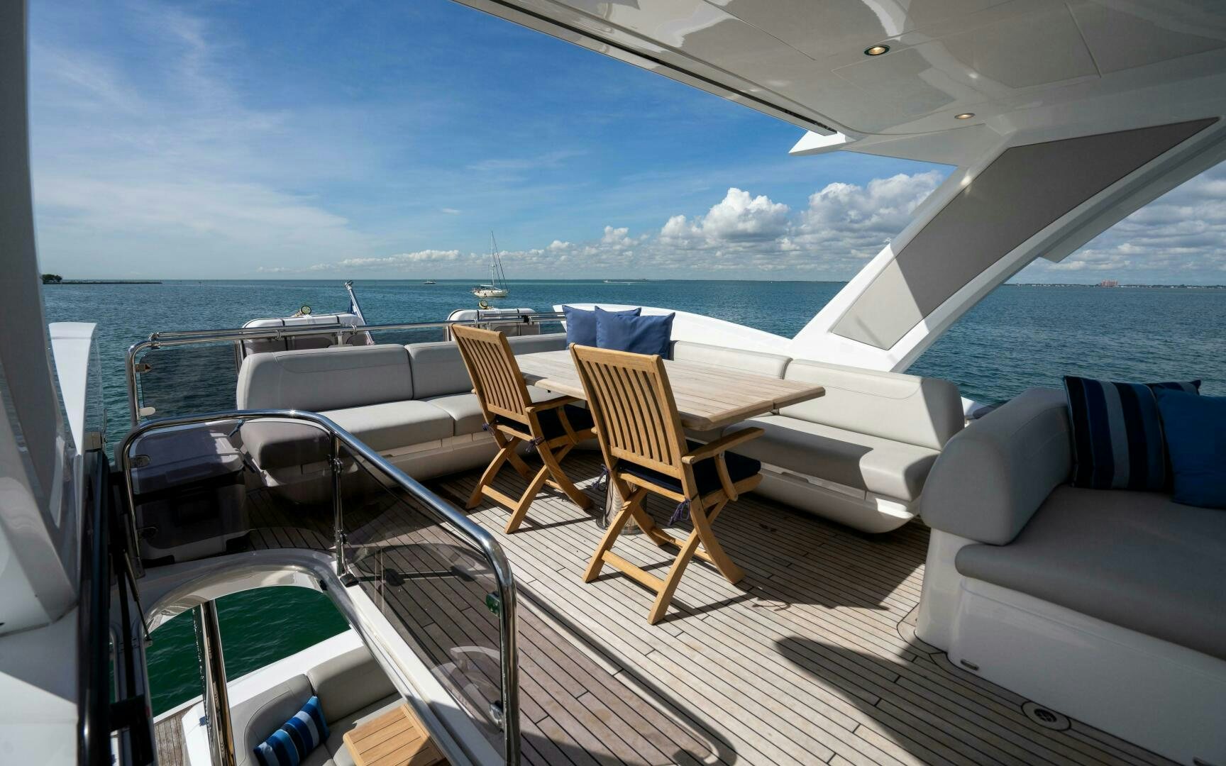a deck with chairs and a table on it aboard 4-PLAY VII Yacht for Sale