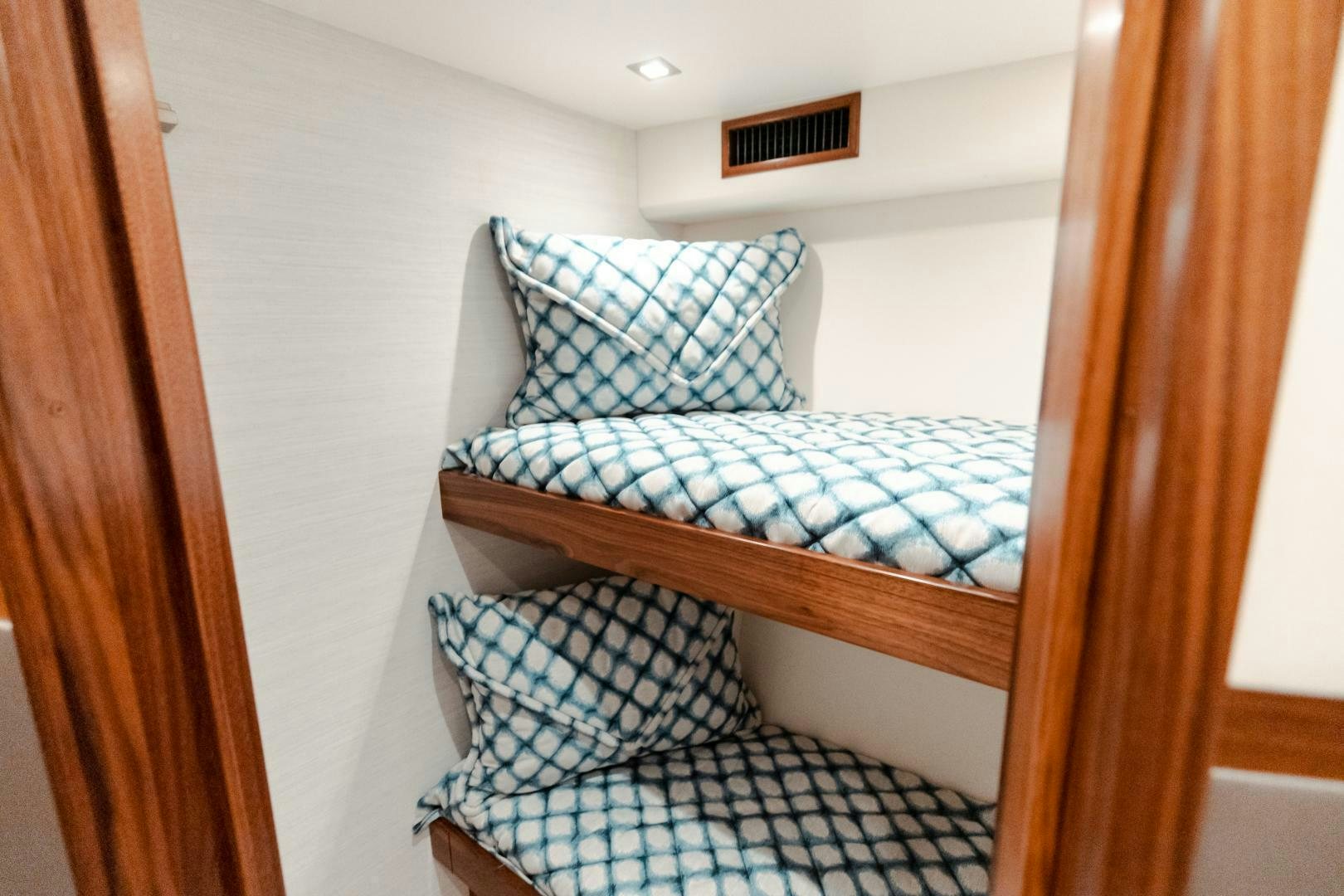 a bed with a blue and white striped comforter aboard AEI Yacht for Sale