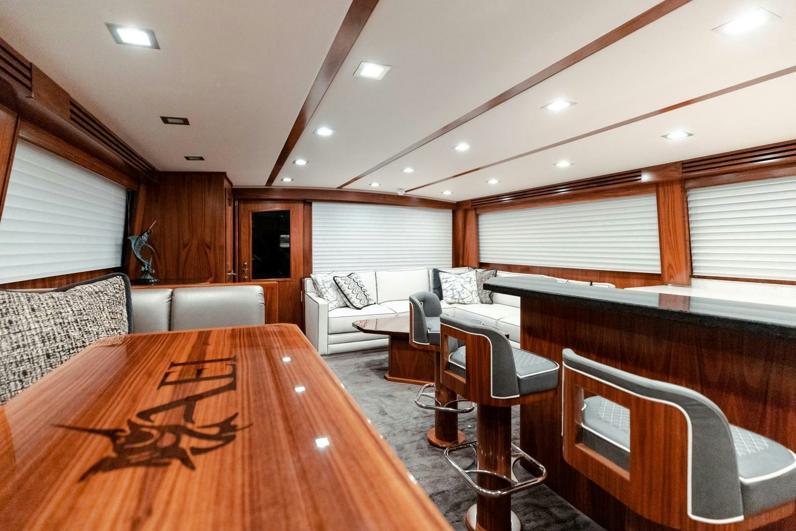 a large living room with a wood floor and white couches aboard AEI Yacht for Sale