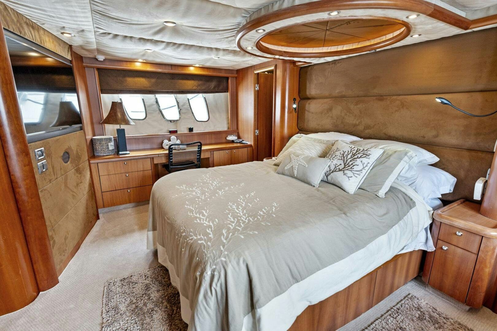a bedroom with a bed and a chandelier aboard PERSISTENCE Yacht for Sale