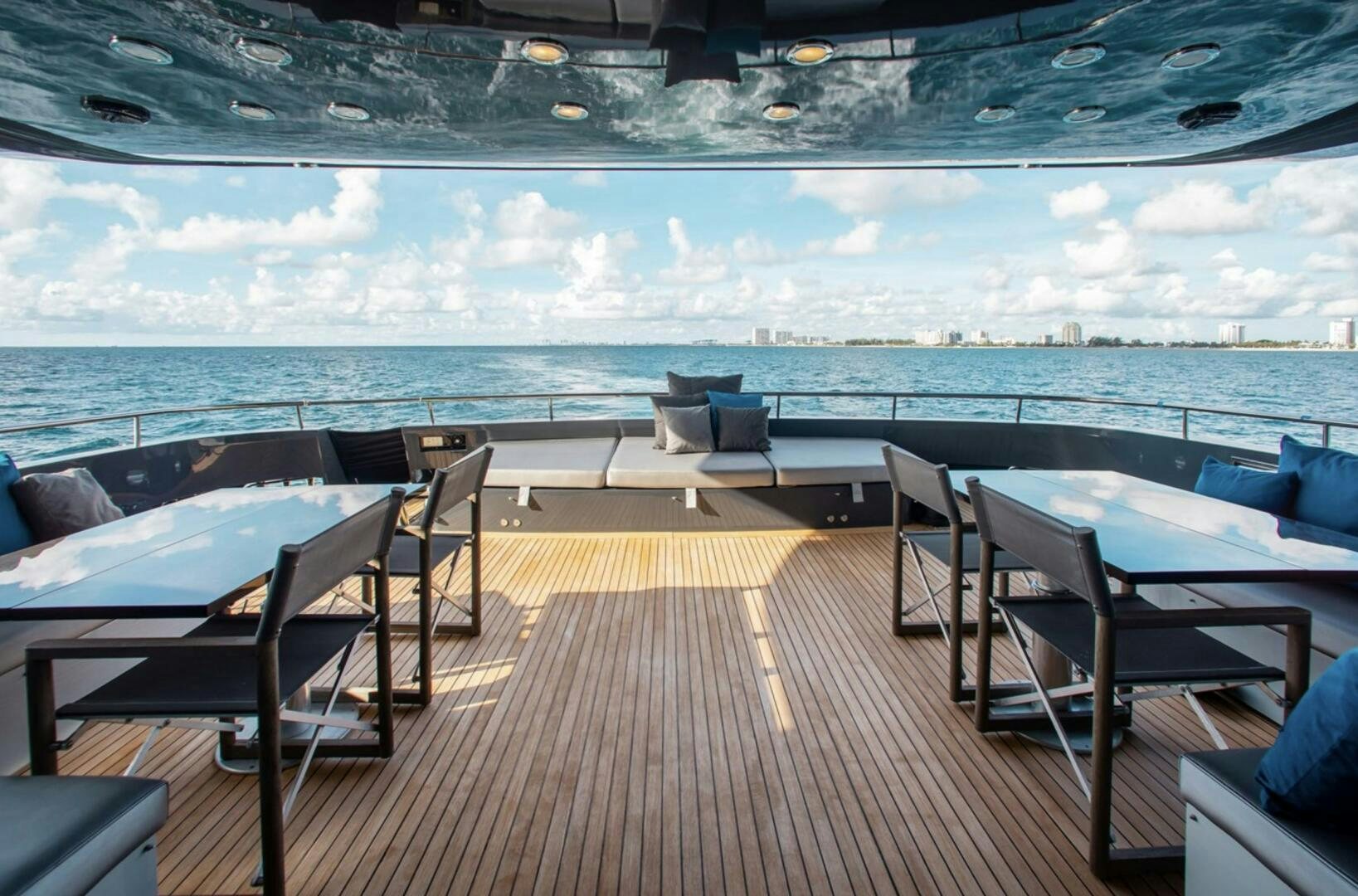 a deck with chairs and a body of water in the background aboard MATRIX Yacht for Sale