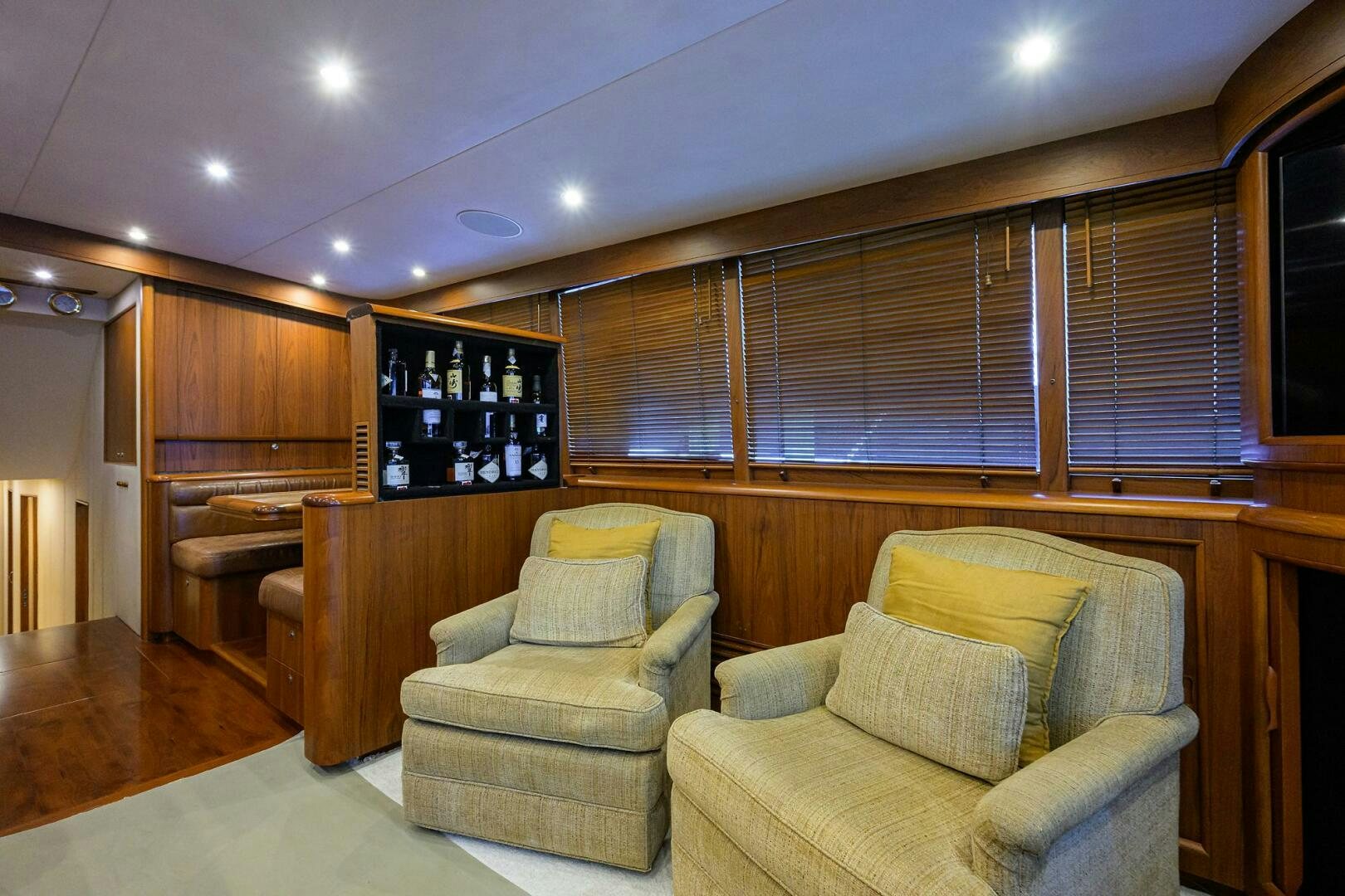 a room with a couch and a shelf with wine bottles aboard BUSINESS STINKS Yacht for Sale