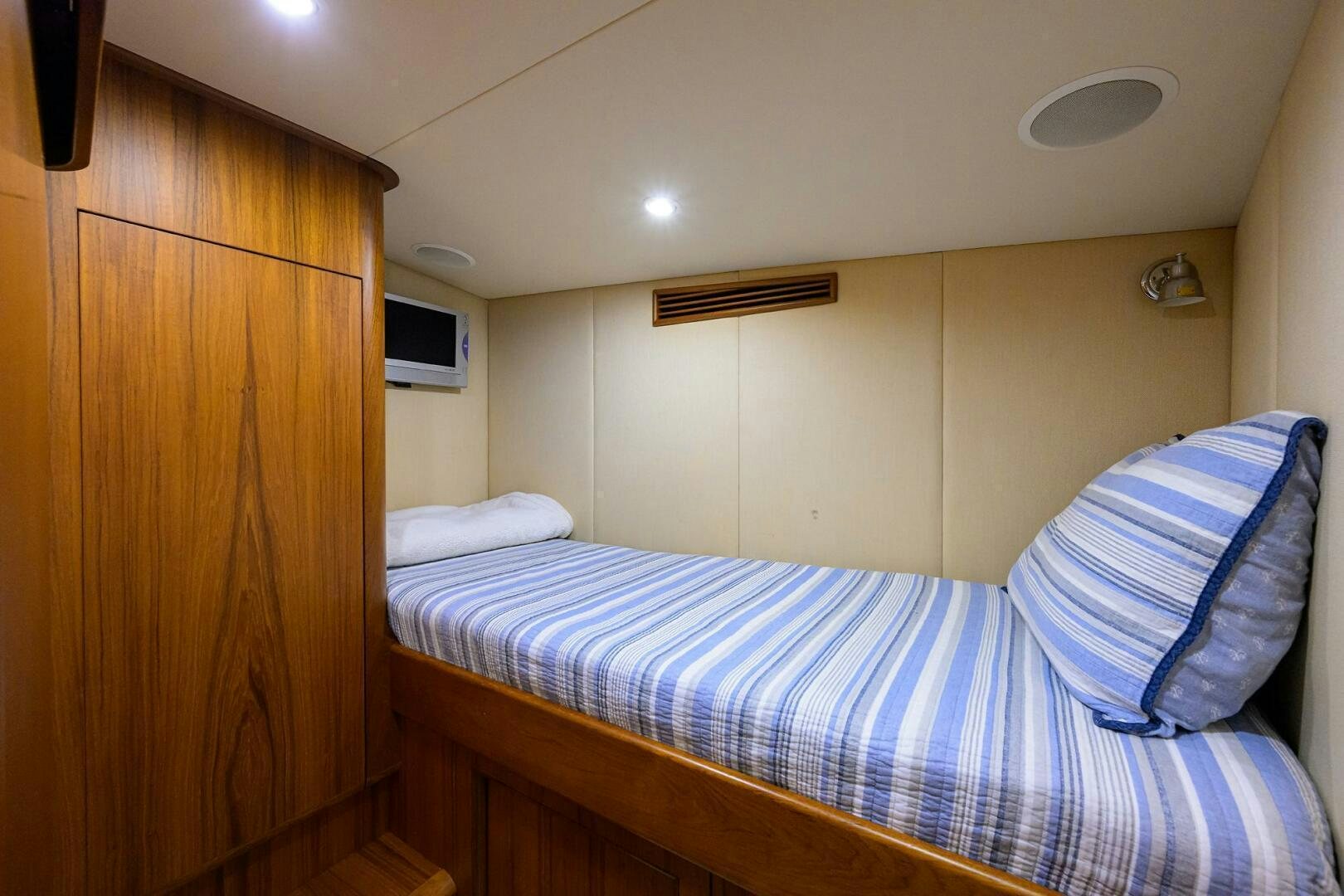 a bed with a blue and white striped sheet aboard BUSINESS STINKS Yacht for Sale