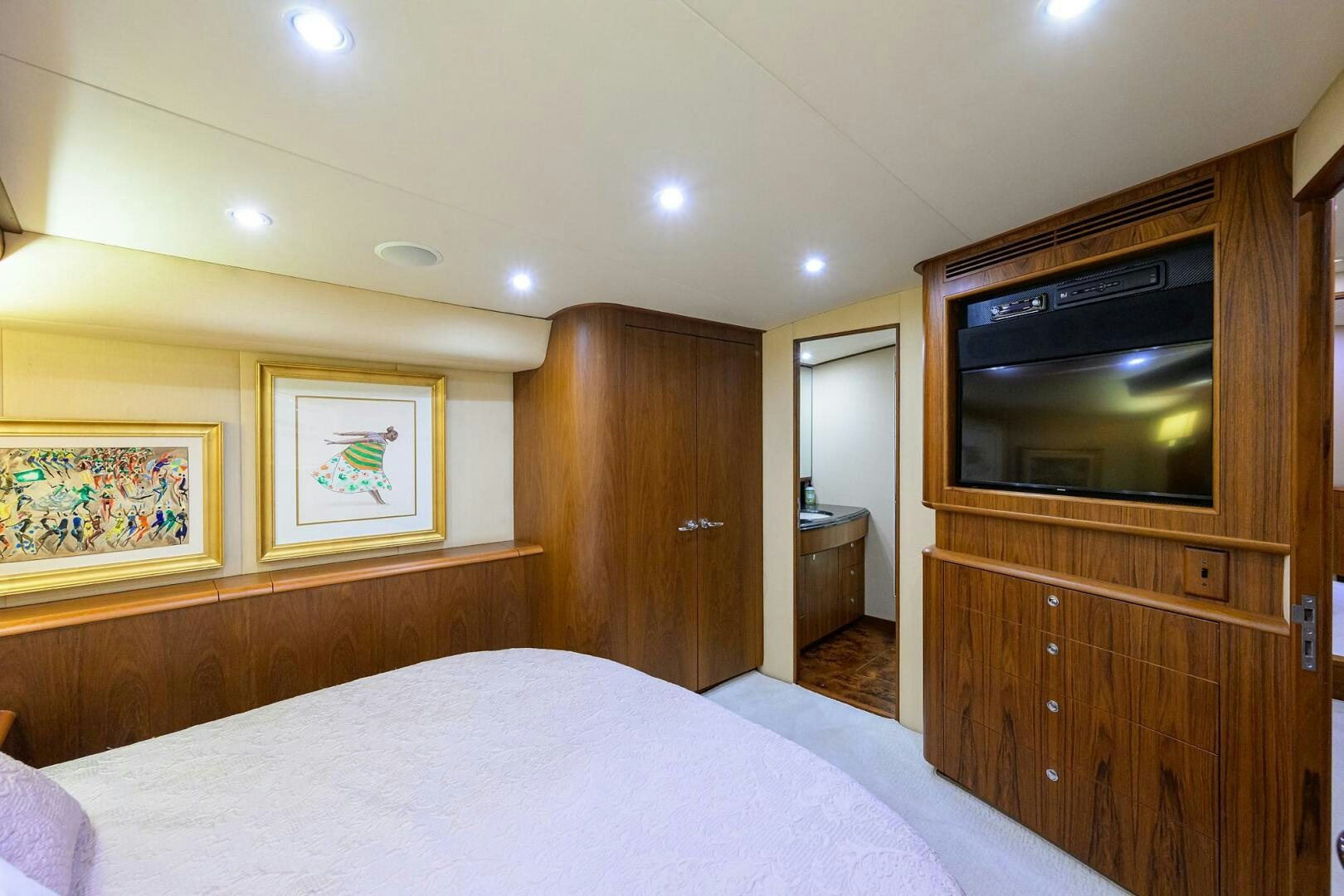 a bedroom with a bed and a television aboard BUSINESS STINKS Yacht for Sale