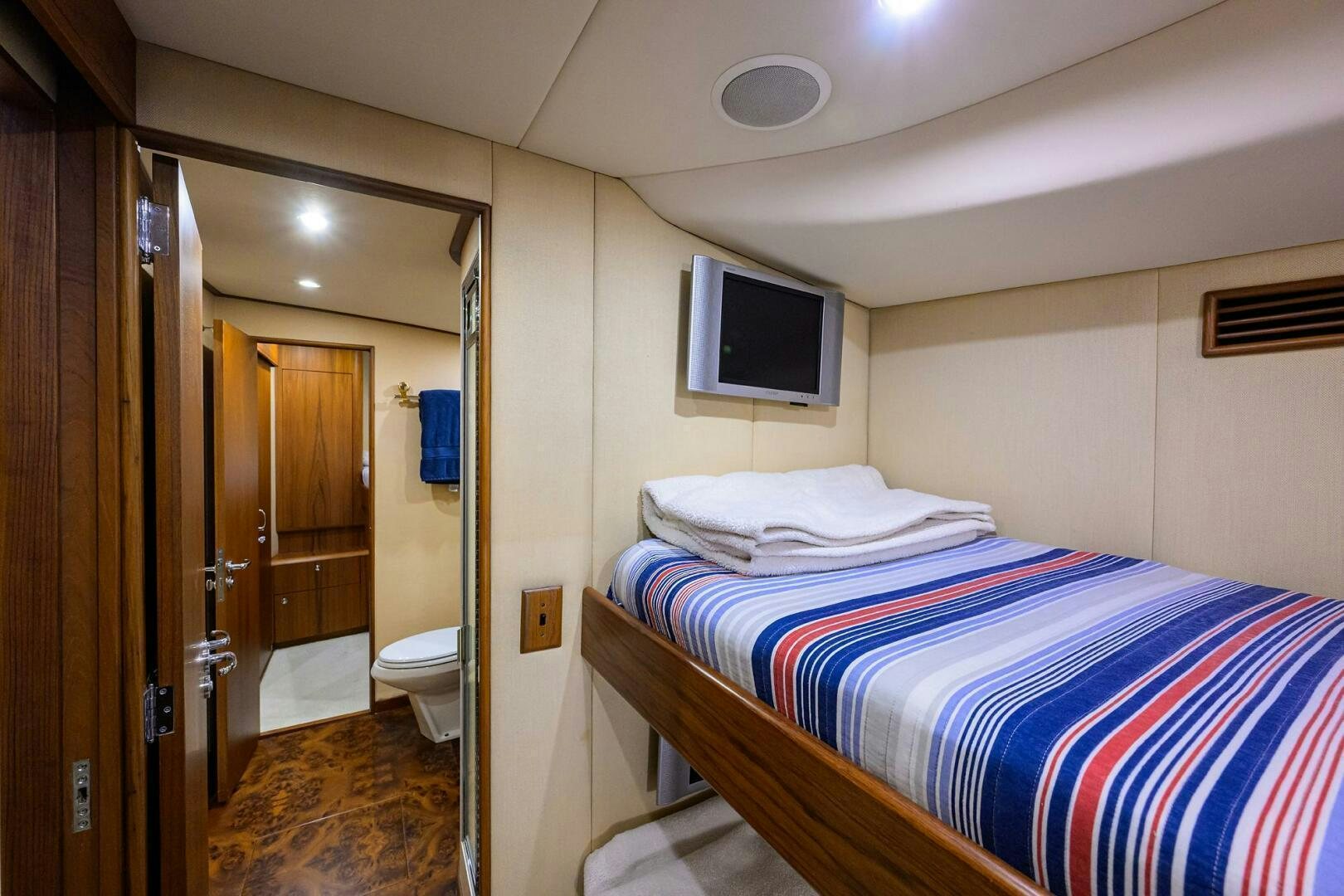 a bedroom with a bed and a television aboard BUSINESS STINKS Yacht for Sale