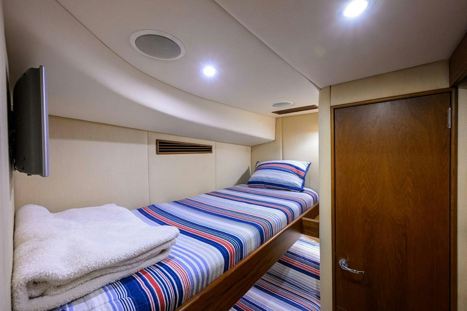 a room with a bed and a television aboard BUSINESS STINKS Yacht for Sale