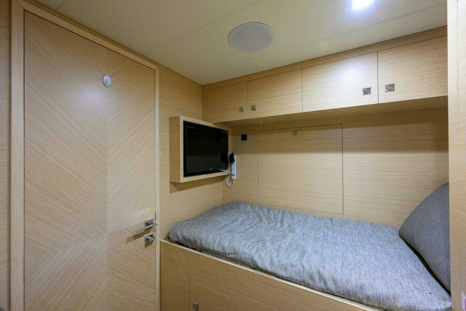 a bedroom with a bed and a television aboard JOURNEY Yacht for Sale