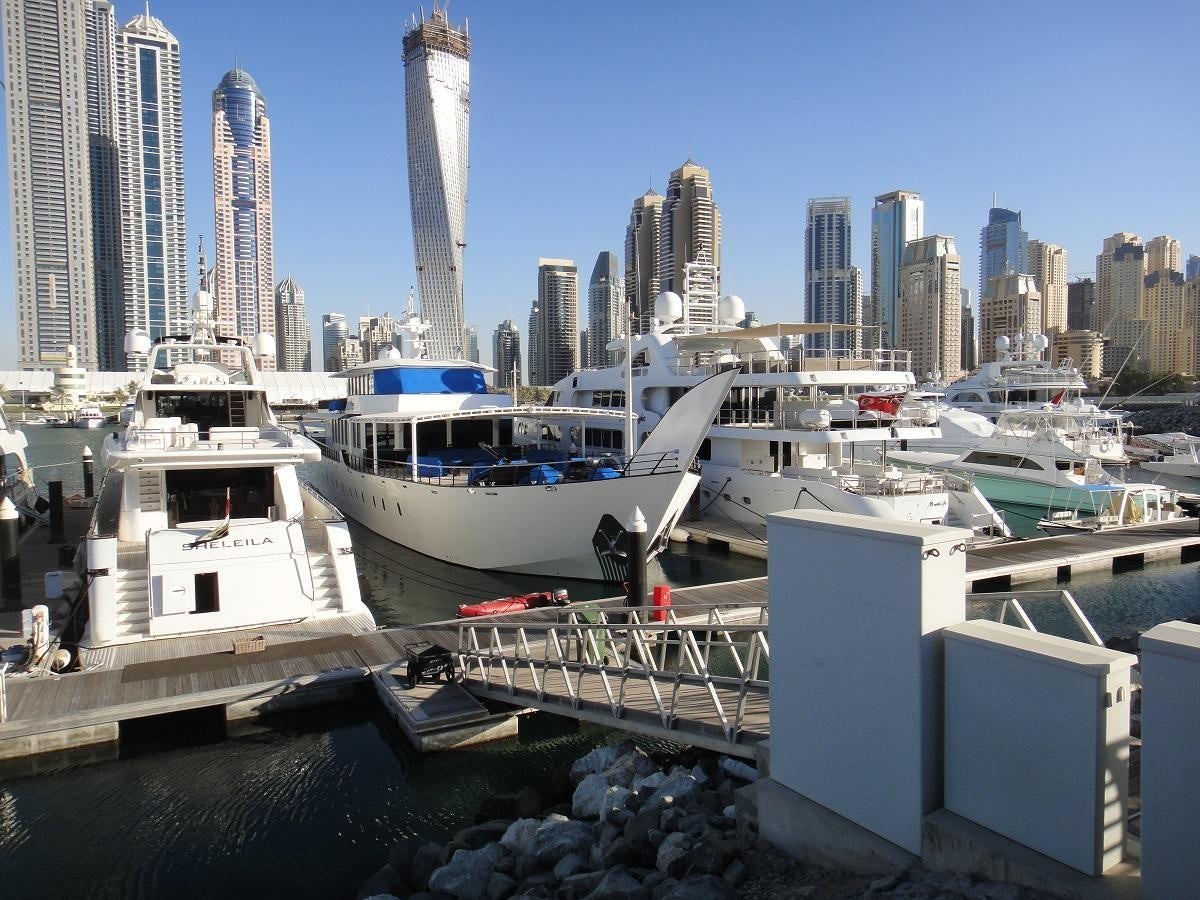 a marina with boats and city skyline aboard WARSAN Yacht for Sale