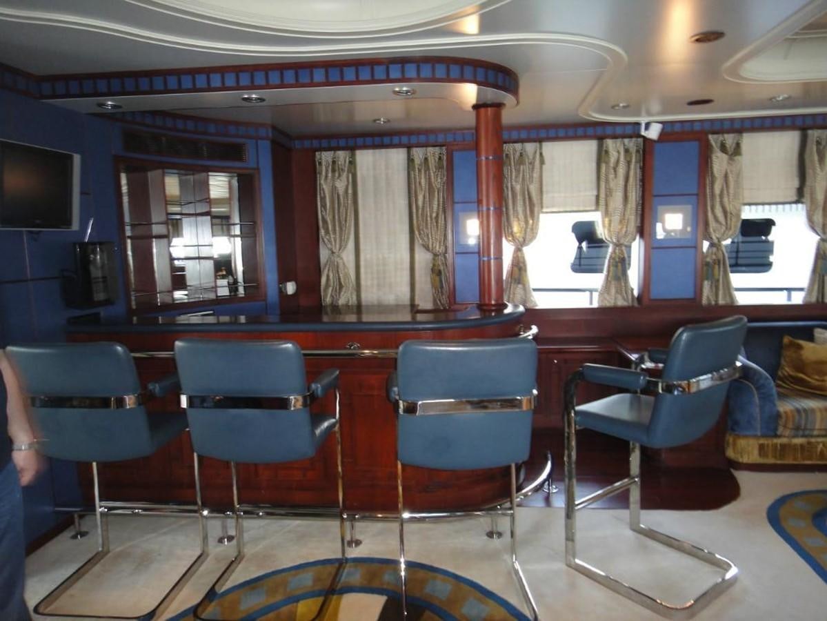a room with blue chairs and a table with a curtain aboard WARSAN Yacht for Sale