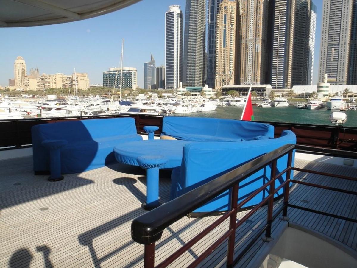 a deck with a pool and cityscape in the background aboard WARSAN Yacht for Sale