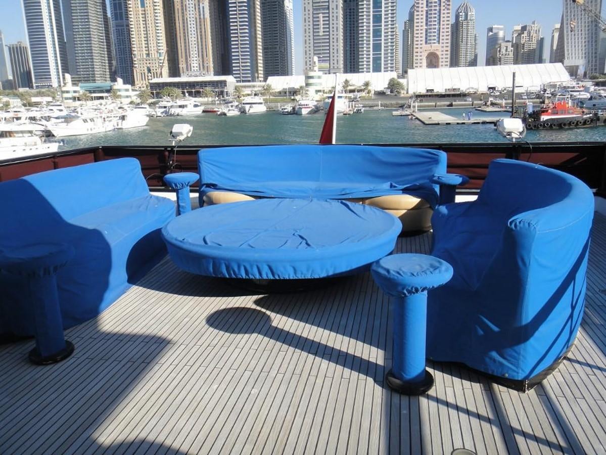 a table with chairs and a table with a view of a city aboard WARSAN Yacht for Sale