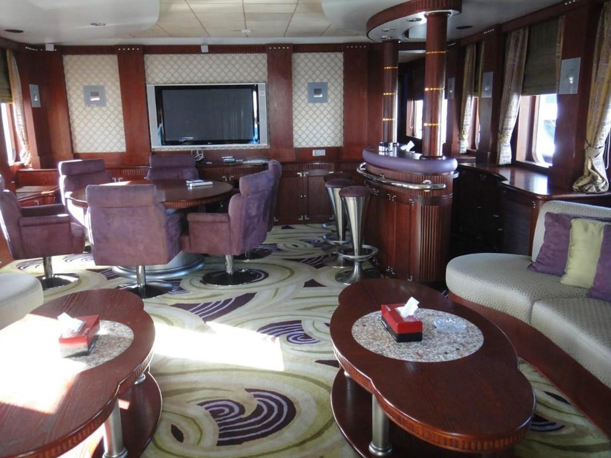 a room with a table chairs and a television aboard WARSAN Yacht for Sale