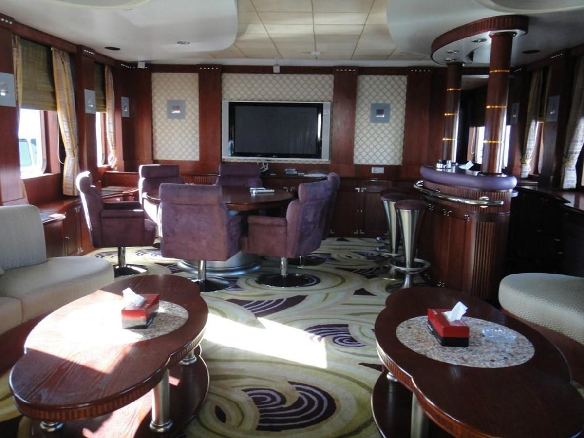 a room with a table chairs and a television aboard WARSAN Yacht for Sale