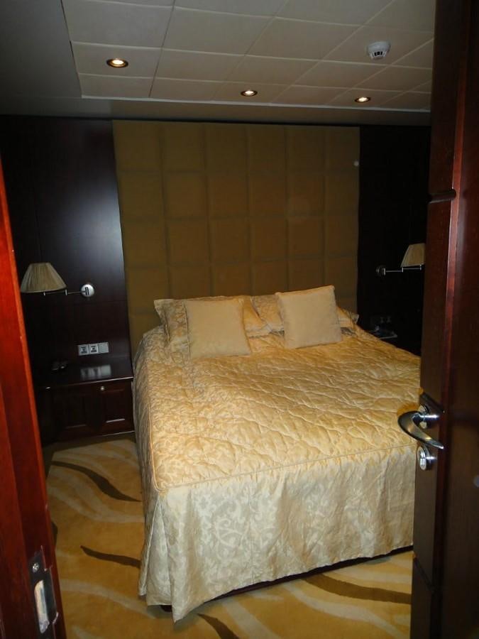 a bed with a yellow comforter aboard WARSAN Yacht for Sale
