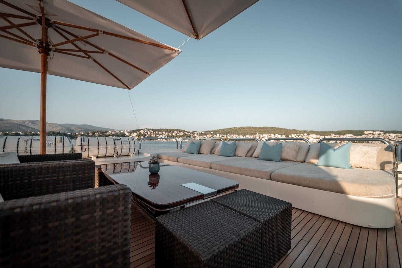 a patio with a couch and a table with a large umbrella aboard MERCURY Yacht for Sale