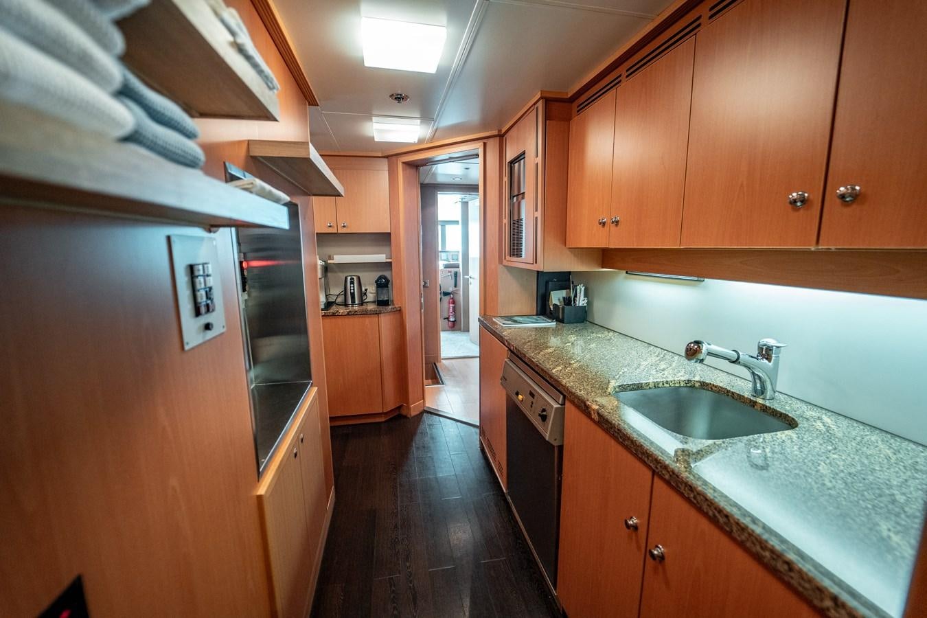 a kitchen with wooden cabinets aboard MERCURY Yacht for Sale