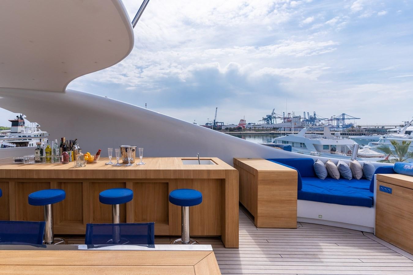 a table with chairs and a boat in the background aboard UNDER CONTRACT!   SAINT  2012 ISA 500-2 POP @ Yacht for Sale