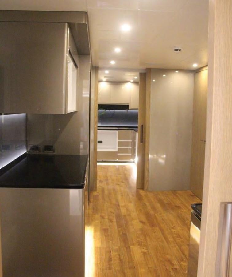 a hallway with a wood floor and a black counter top aboard HULL#05 Yacht for Sale