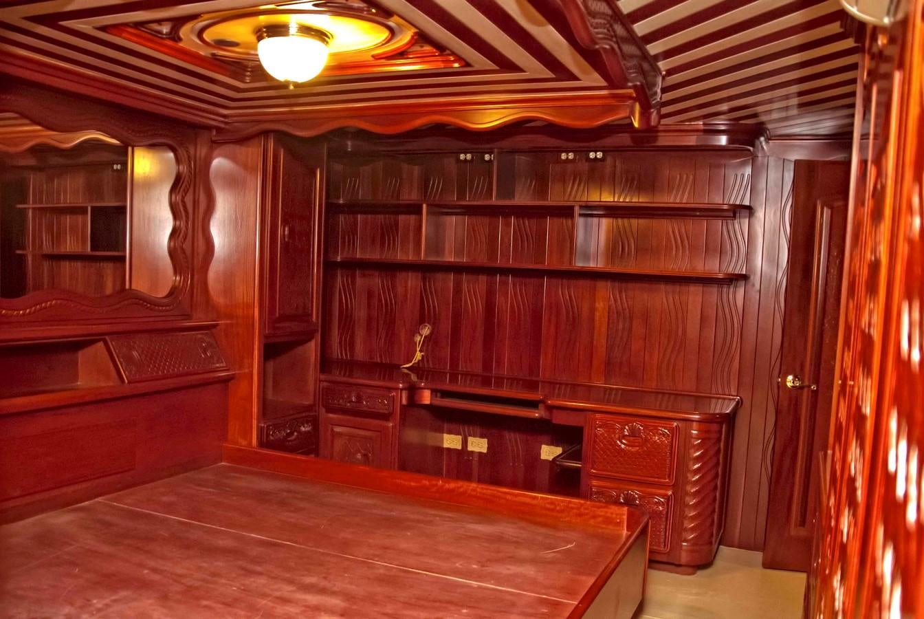 a room with wooden furniture aboard PRINCIPE DEL MAR Yacht for Sale