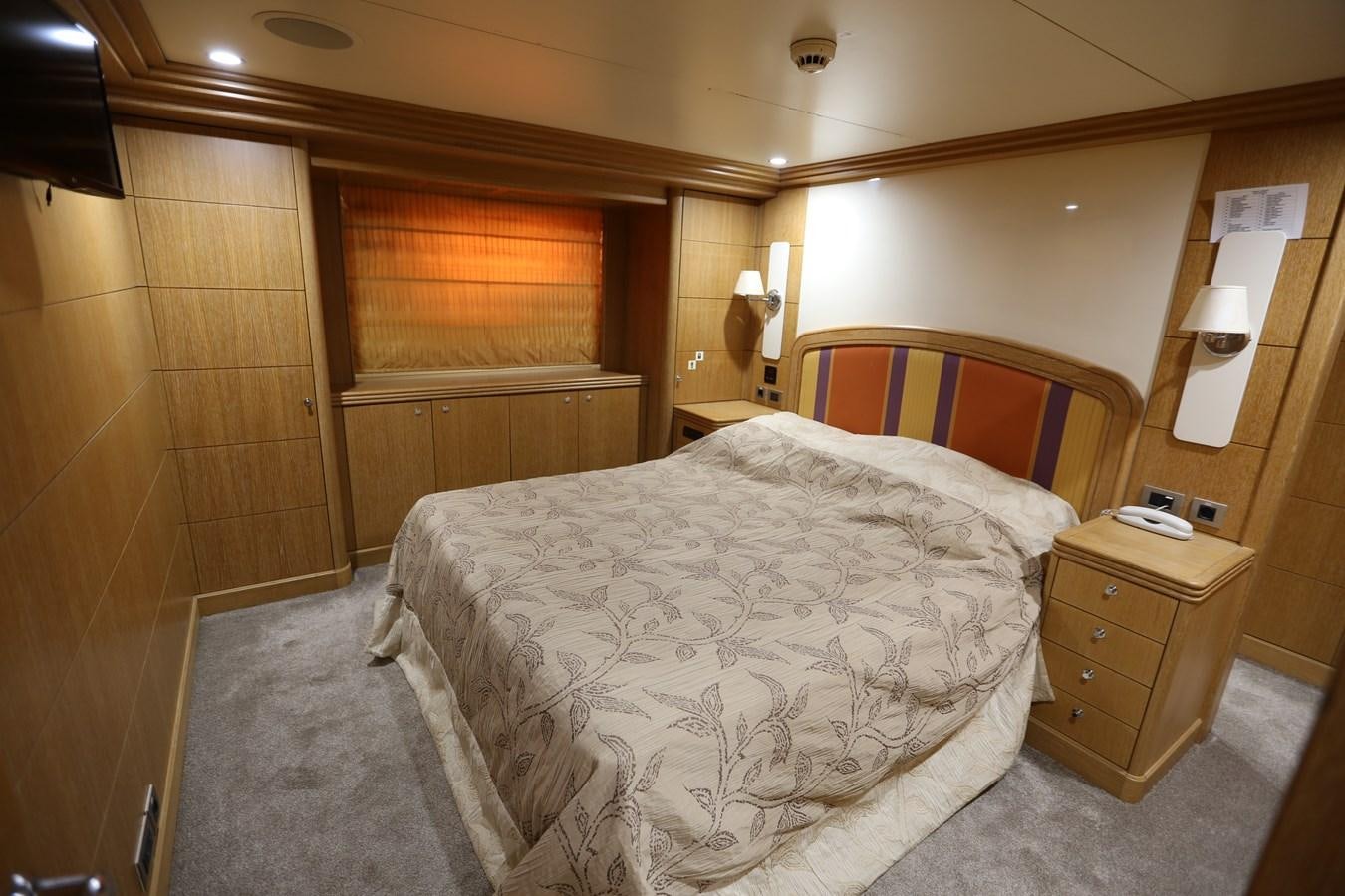 a bedroom with a bed and a dresser aboard GOODWILL Yacht for Sale