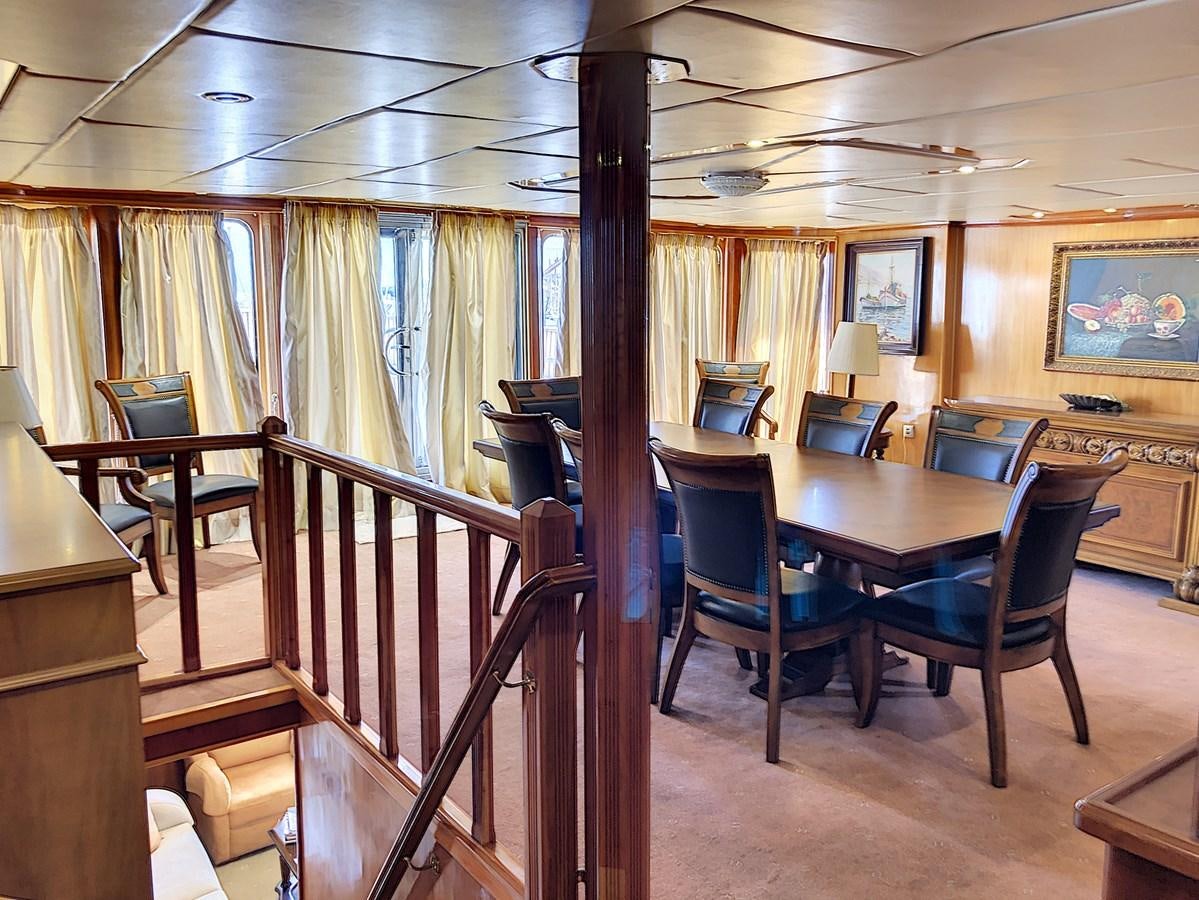 a large room with a table and chairs aboard ELIKI Yacht for Sale