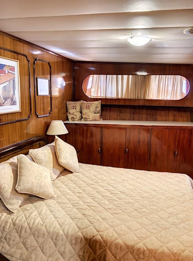 a bed with a yellow comforter aboard ELIKI Yacht for Sale