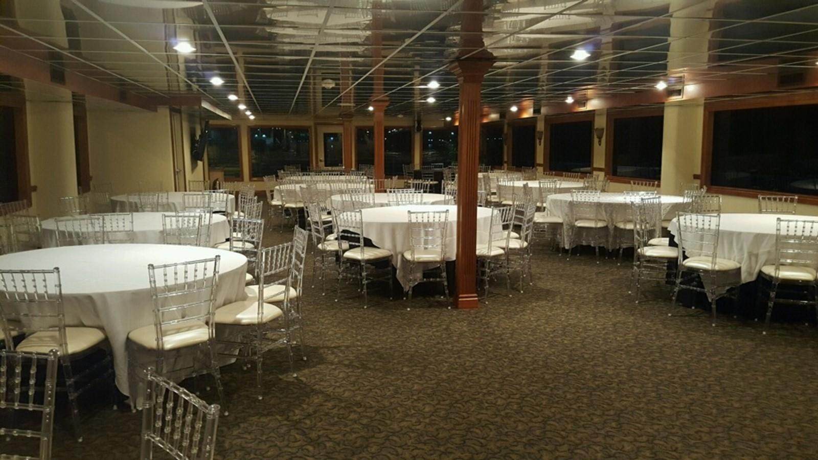 a room with tables and chairs aboard SIR WINSTON Yacht for Sale