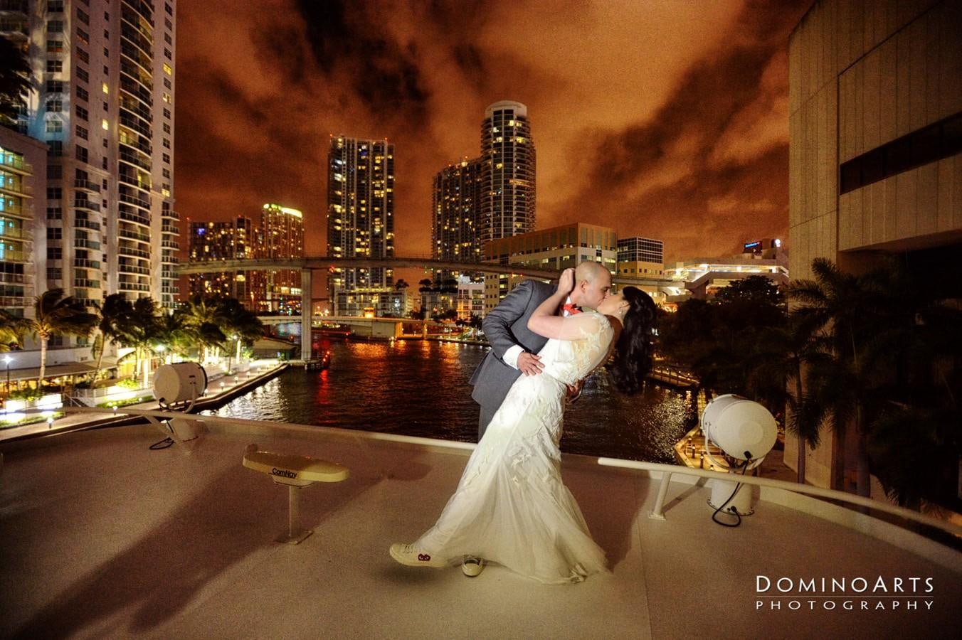 a man and woman kissing on a rooftop with a city in the background aboard SIR WINSTON Yacht for Sale