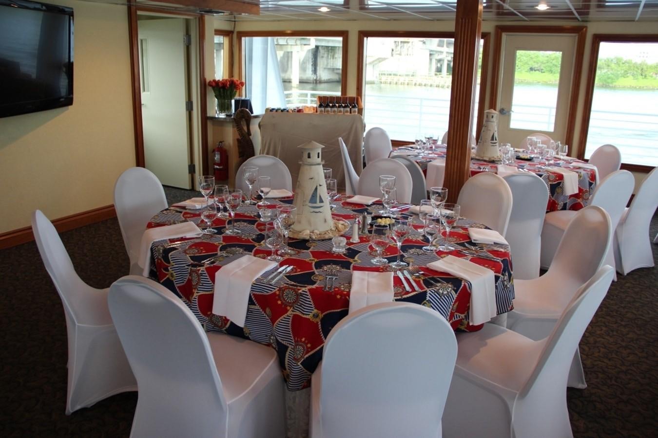 a table set with white chairs and white chairs aboard SIR WINSTON Yacht for Sale
