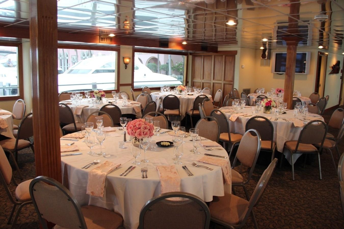 a room with tables and chairs aboard SIR WINSTON Yacht for Sale