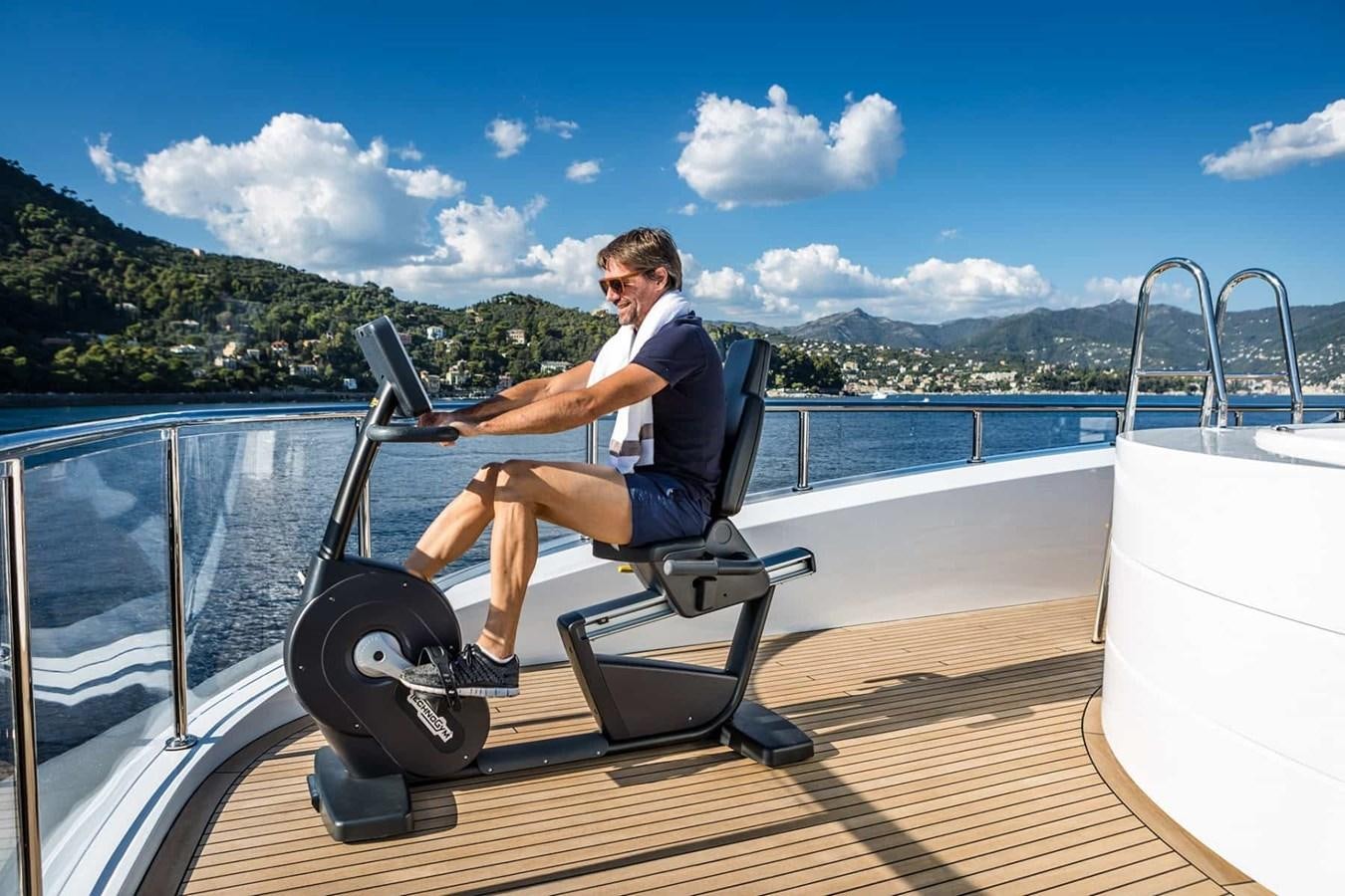 a person sitting on a boat with a laptop aboard GTT 130 Yacht for Sale