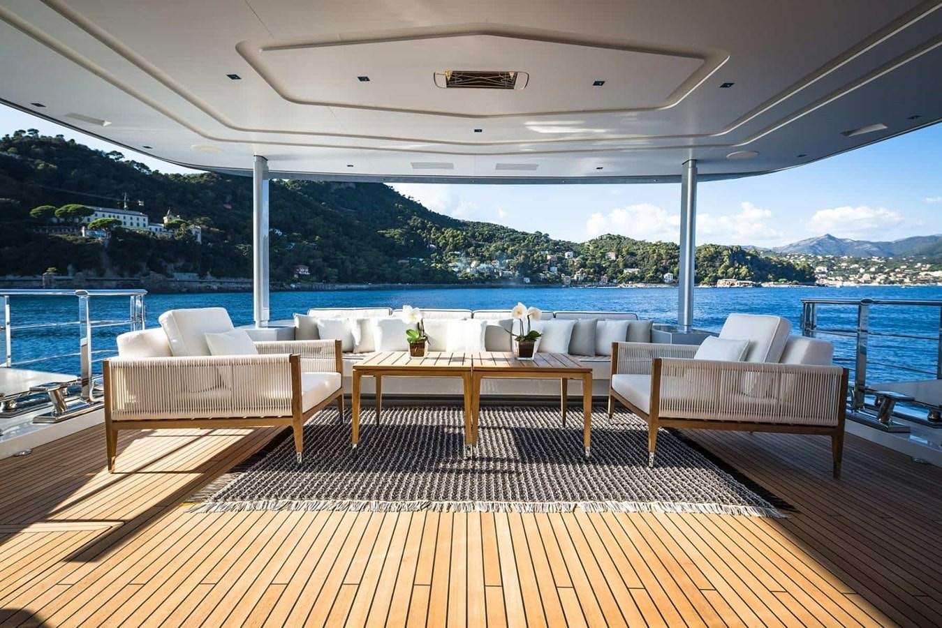 a deck with chairs and a table on it aboard GTT 130 Yacht for Sale