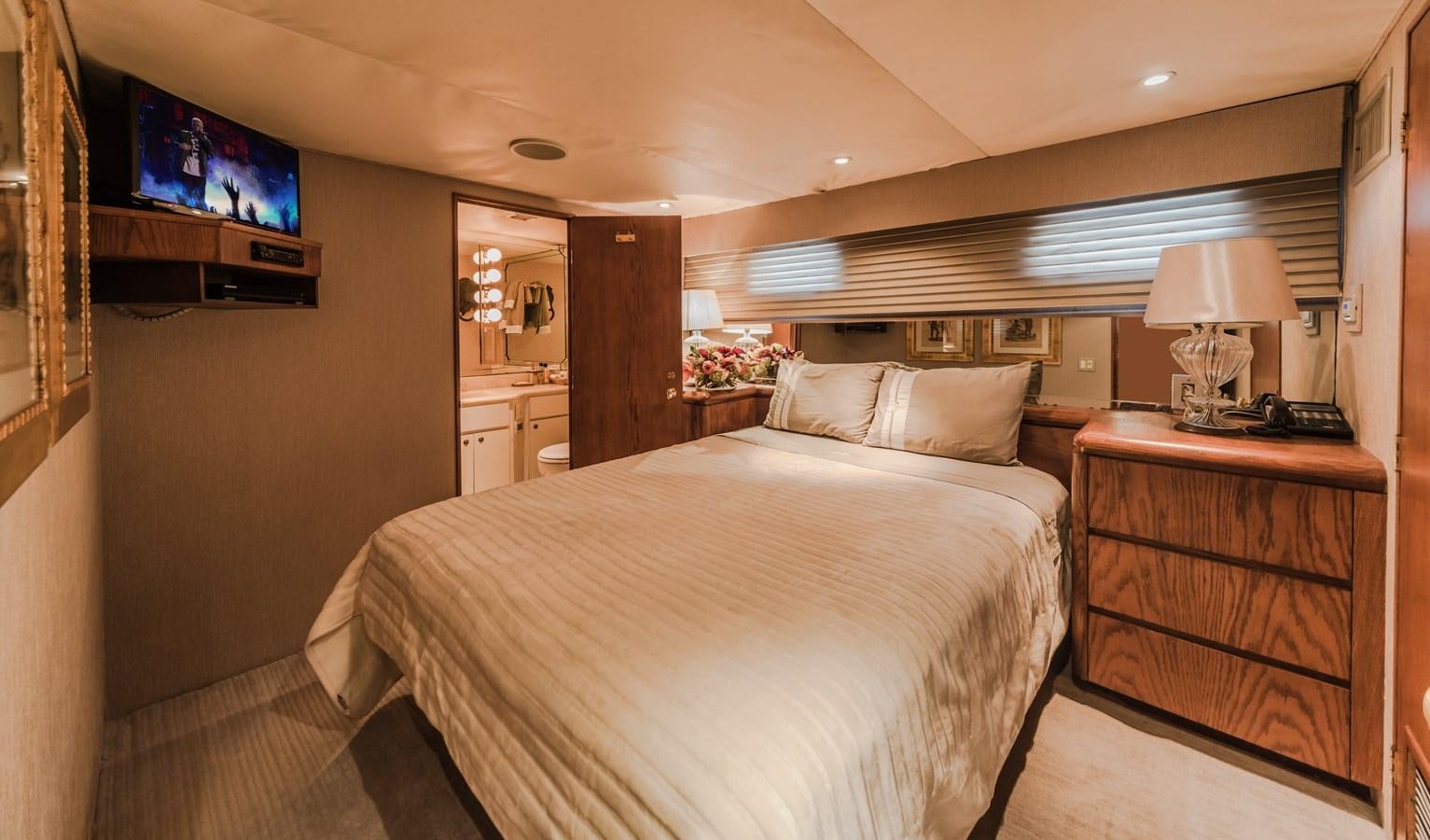 a bedroom with a bed and a television on the wall aboard SU Yacht for Sale