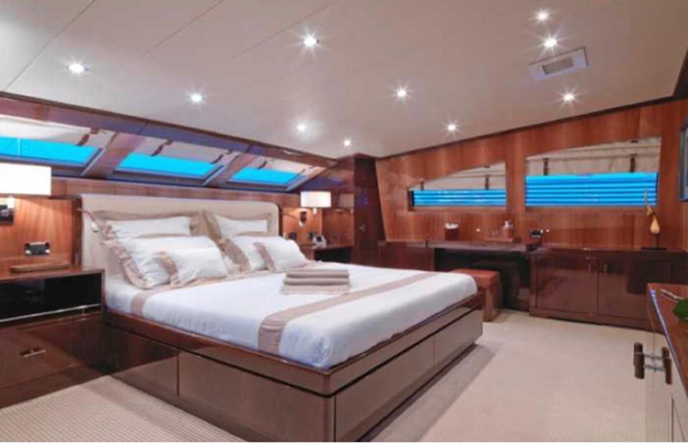 a large room with a bed and a desk aboard COUACH 120 Yacht for Sale