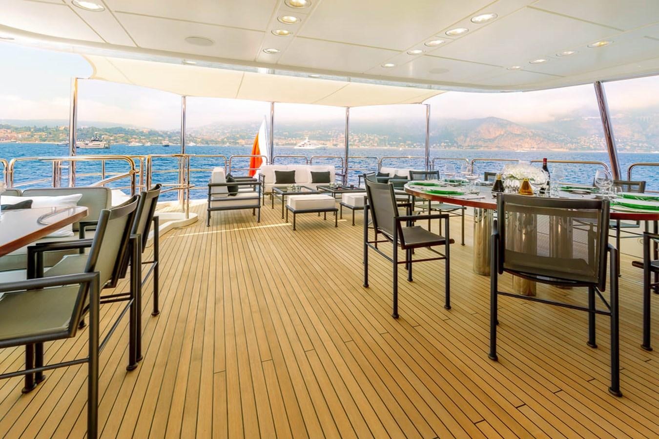 a deck with tables and chairs aboard MINA Yacht for Sale