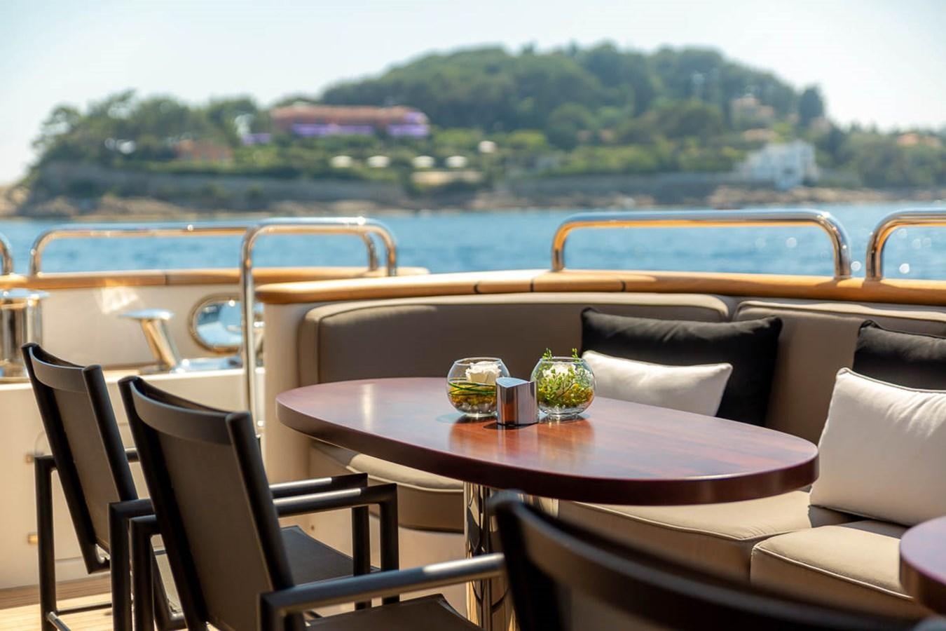 a table with chairs and a view of a body of water aboard MINA Yacht for Sale