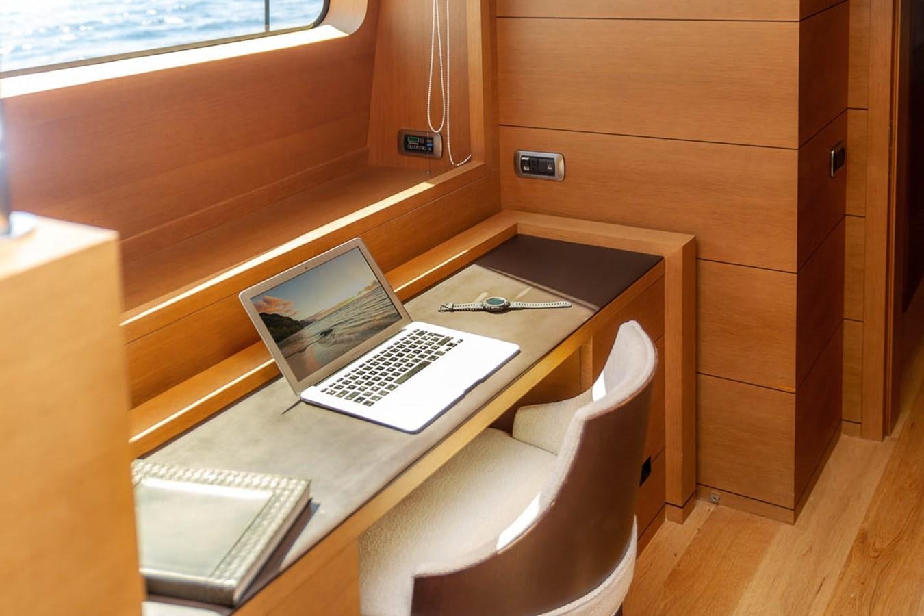 a laptop on a table aboard MINA Yacht for Sale