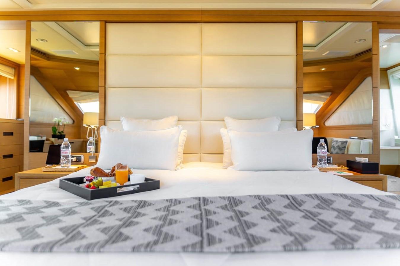 a bed with a tray of food on it aboard MINA Yacht for Sale