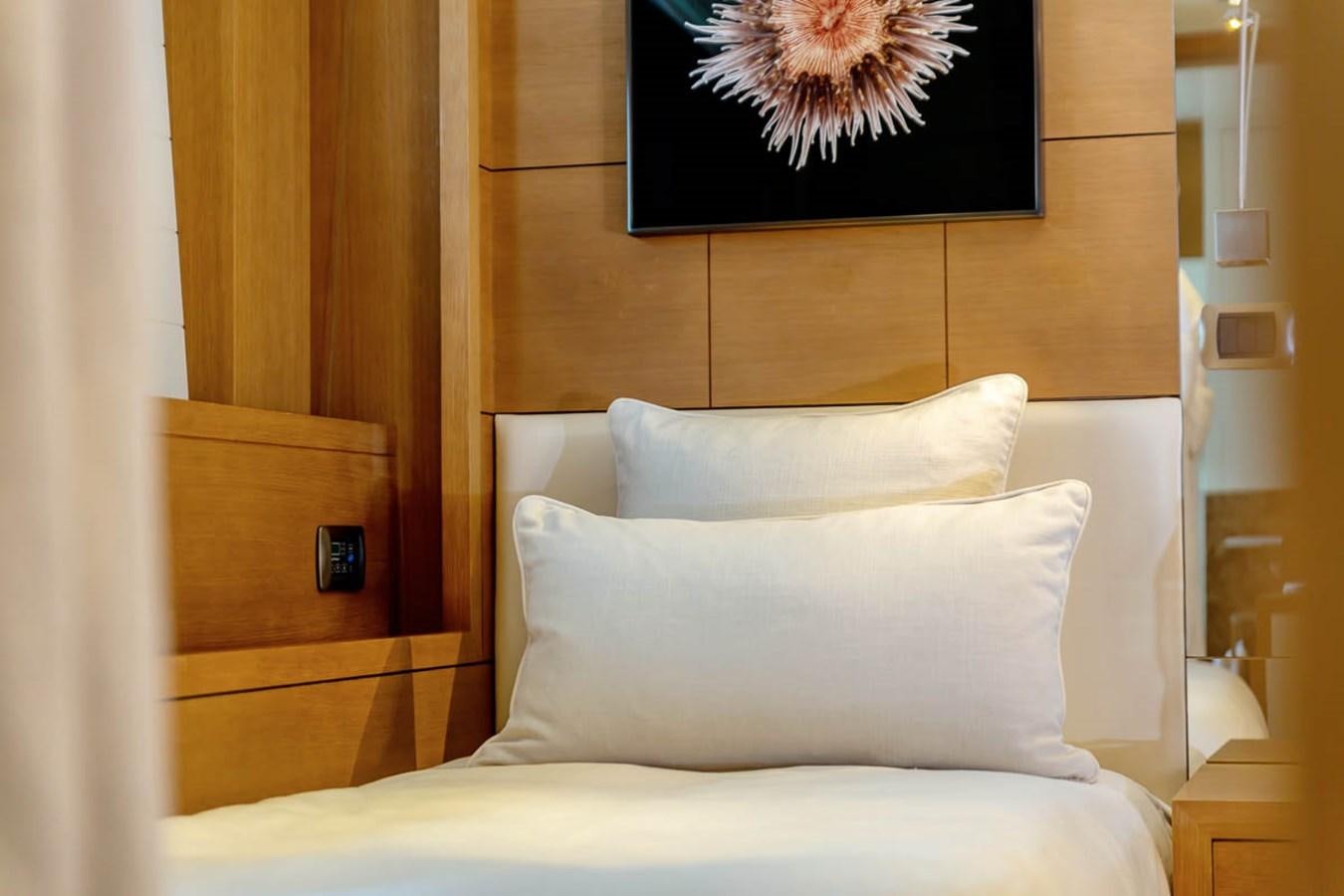 a bed with a painting on the wall aboard MINA Yacht for Sale