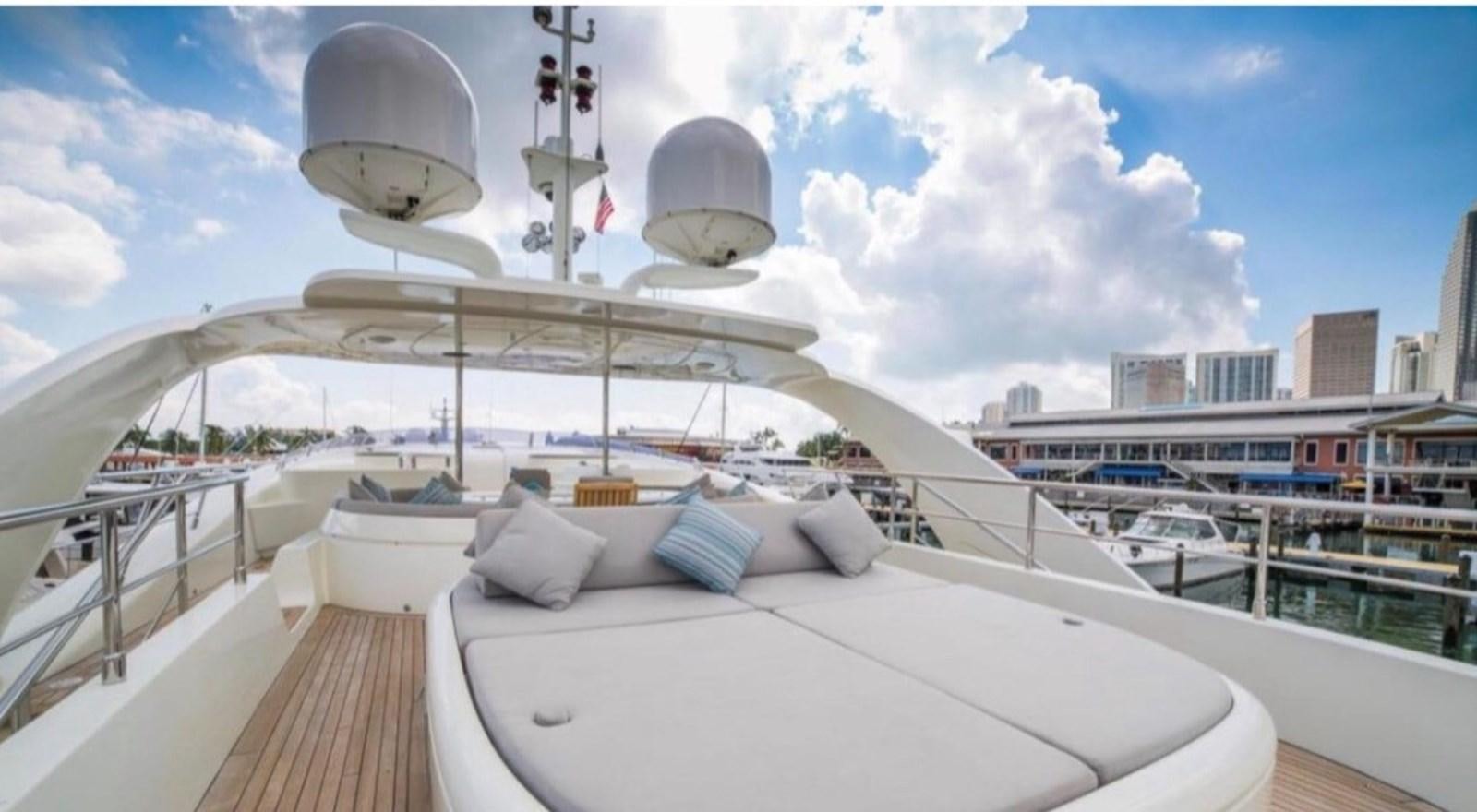a large white lounge chair on a deck overlooking a city aboard MY HAPPY HOUR Yacht for Sale