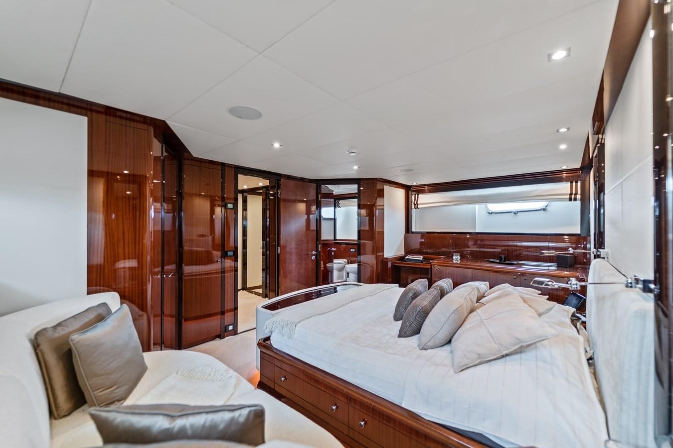 a bedroom with a bed and a wood closet aboard MY HAPPY HOUR Yacht for Sale