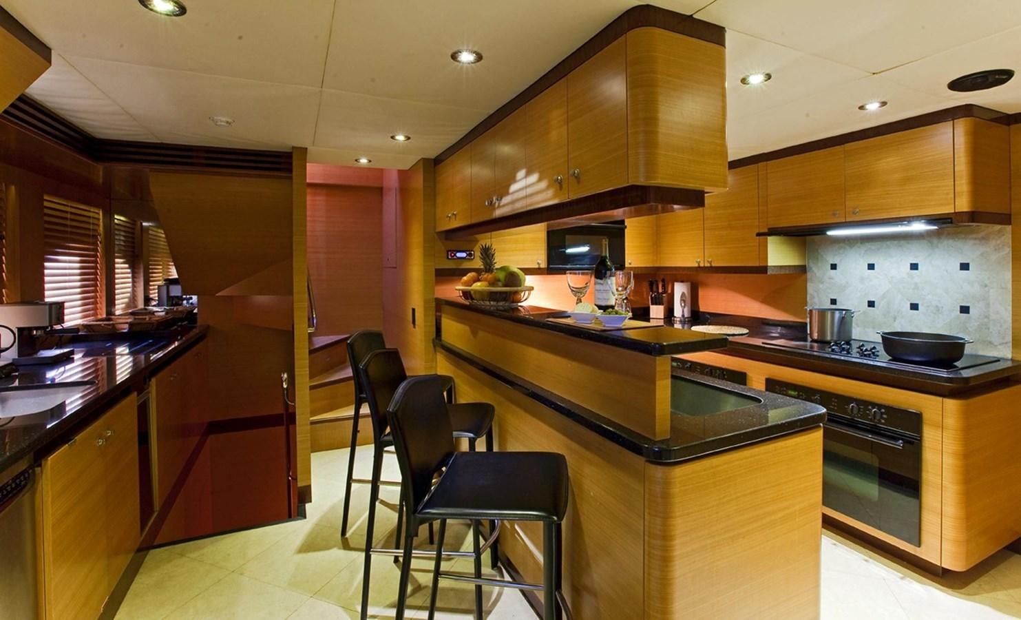 a kitchen with a stove and a table aboard NO NAME  2002 120 TRI-DECK M/Y Yacht for Sale