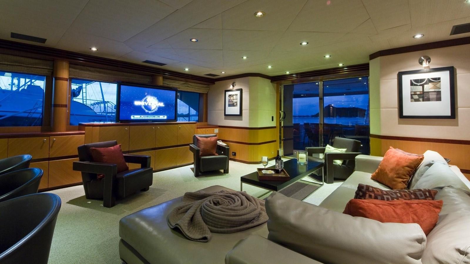 a living room with a large screen aboard NO NAME  2002 120 TRI-DECK M/Y Yacht for Sale