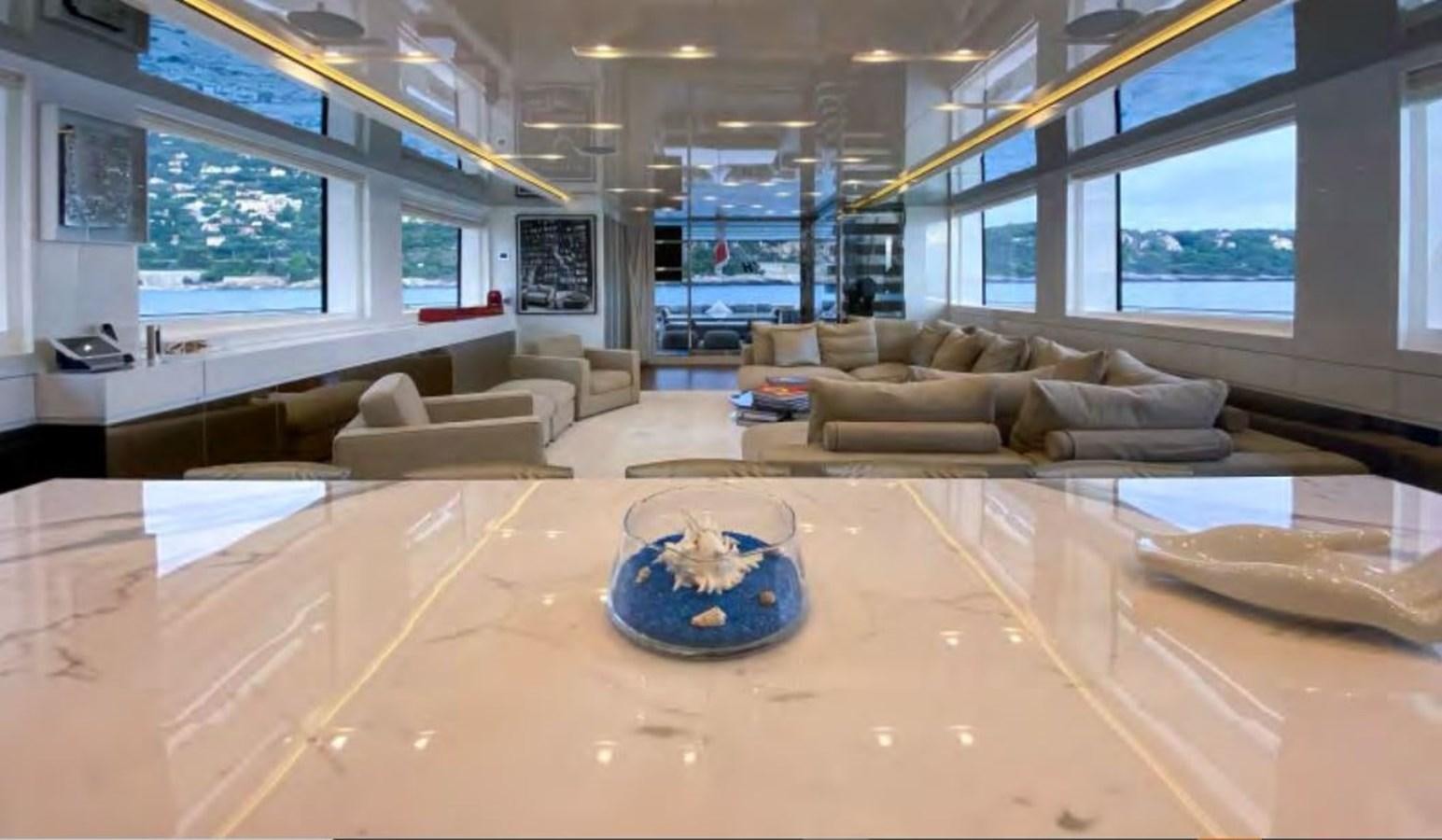 a large living room with a large table and a couch aboard CAIA S Yacht for Sale