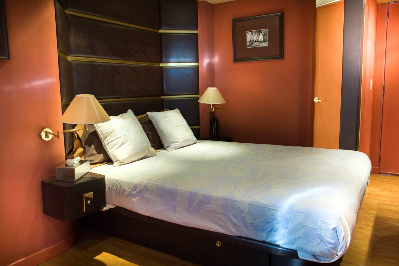 a bed with a blue comforter aboard HAUMANA Yacht for Sale